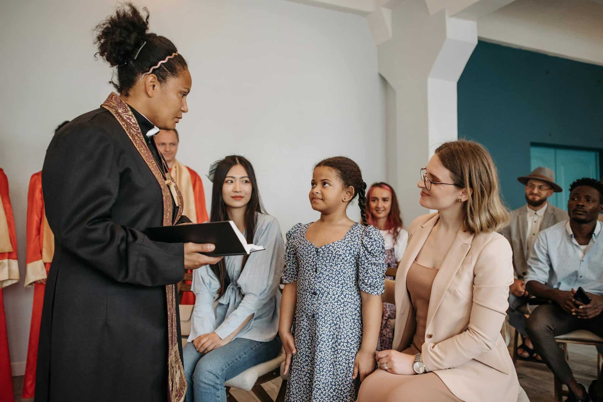 A diverse group of people attending a church service led by a pastor indoors.