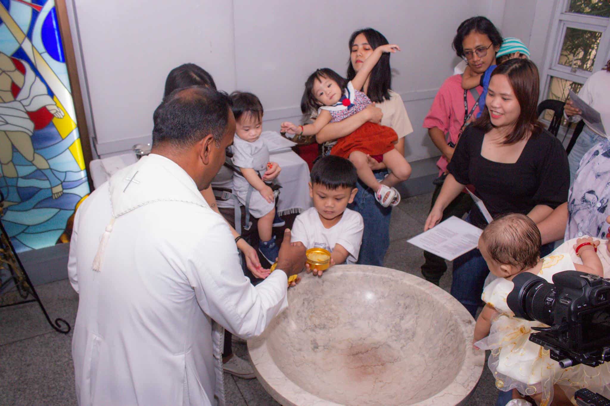 A meaningful church baptism ceremony with children and families gathered around the font.